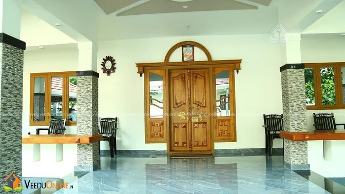 Living room with carved wooden main door in traditional Kerala home