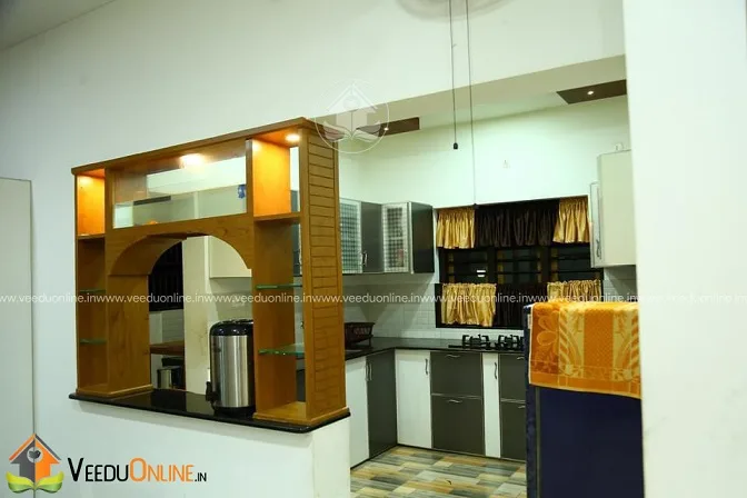 Kerala home kitchen with wooden open shelves and arched counter
