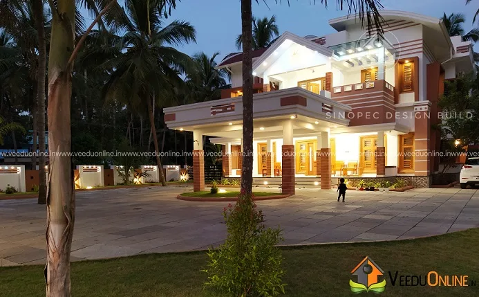 Front view of grand Kerala house among palm trees