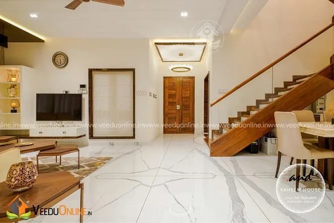 Living area with wooden staircase and TV unit on marble floor