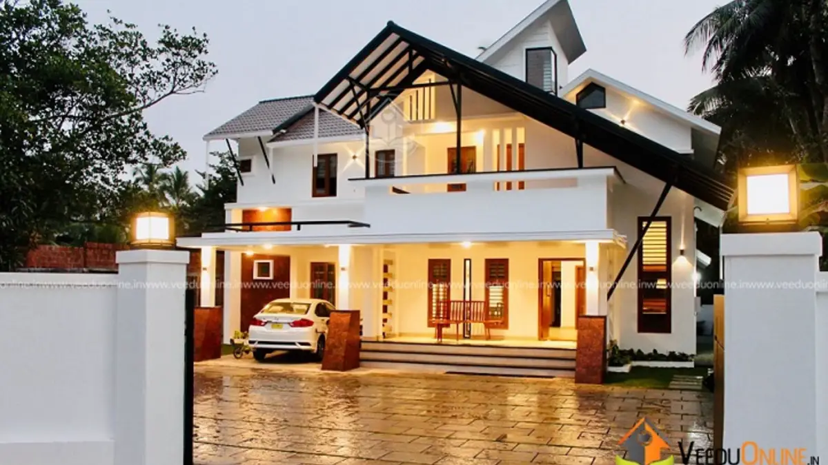 Kerala house with double height living 2550 sq ft at night with sloping roof
