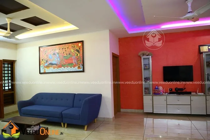 Red feature wall with TV unit in Kerala home