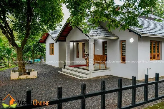 Side view of tiled roof house among trees