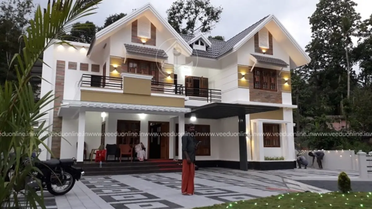 Sloping roof house design 2400 sq ft double floor Kerala home at night